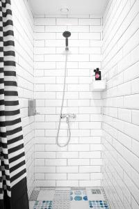 a white bathroom with a shower with a shower head at Luna in Vladivostok