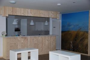 a kitchen with white furniture and a blue wall at Minicamping De Visser in Zoutelande