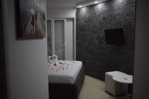 een kamer met een bed, een televisie en een badkamer bij Villa la vie in Ulcinj