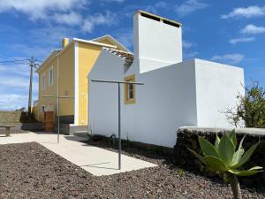 dom z białymi ścianami i żółtym w obiekcie CASA do CAMINHO w mieście Praia da Vitória