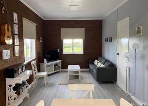 ein Wohnzimmer mit einem Sofa und einem TV in der Unterkunft CASA do CAMINHO in Praia da Vitória