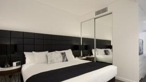 a bedroom with a large bed with a large mirror at KOZYGURU Chatswood Luxury Studio NCH088-720 in Sydney