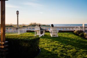 two people sitting on a bench overlooking the ocean at Inn at the Prom in Seaside