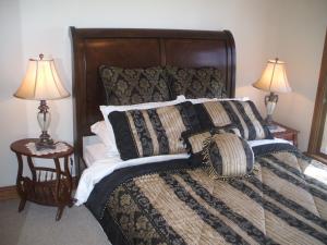 a bedroom with a bed with pillows and two lamps at Archery Road Estate in Rowland Flat