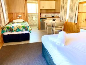 a hotel room with two beds and a kitchen at Holbrook Motor Village in Holbrook
