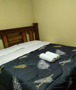 een bed met een blauw dekbed met 2 handdoeken erop bij Alken Homes - One Bedroom, Naivasha in Naivasha