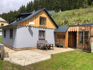 a small house with a patio and a table at Einser Hütte GesbR - Selbstversorgerhaus für 7 Personen in Vordernberg
