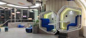 a lobby with two luggage chairs and tables at YELLO Hotel Kuta Beachwalk Bali in Kuta