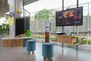 a room with a large tv and two blue stools at YELLO Hotel Kuta Beachwalk Bali in Kuta