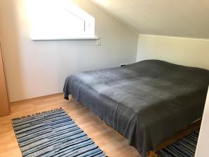 a bedroom with a bed with a rug and a window at Apartment Viiger in Kärdla