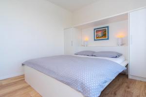 a white bedroom with a large bed with two pillows at The Blueview Appartements Novigrad in Novigrad Istria