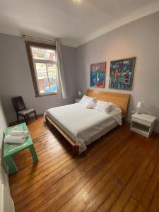 een slaapkamer met een bed en een houten vloer bij Casa Urriola B&B in Valparaíso