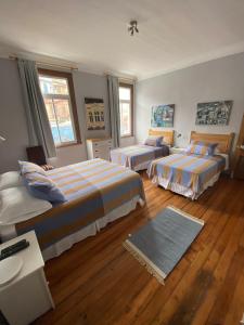 a hotel room with two beds and a desk at Casa Urriola B&B in Valparaíso +21 photos