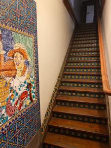 een trap met een mozaïek aan de muur en een muurschildering bij Casa Urriola B&B in Valparaíso