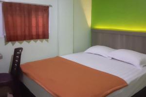 Postel nebo postele na pokoji v ubytování Guest House Anak Raja Pangkalan Bun Syariah Mitra RedDoorz