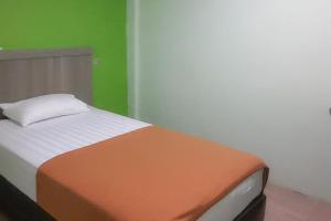 Postel nebo postele na pokoji v ubytování Guest House Anak Raja Pangkalan Bun Syariah Mitra RedDoorz
