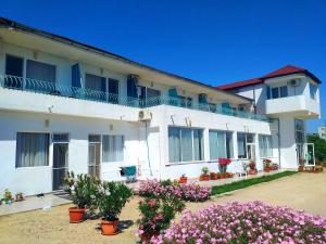 un edificio blanco con flores delante en Sani Family Hotel, en Byala