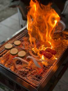 een grill met wat eten dat in brand staat bij YAMAYA BASE 1 in Ōkawamochi