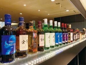 una fila de botellas de vino en un estante de una tienda en Hotel Abest Sapporo en Sapporo