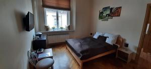Apartments Sobieski&Soplica في كراكوف: غرفة نوم صغيرة بها سرير ونافذة