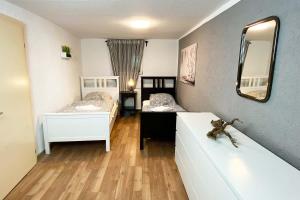 a room with two beds and a mirror at Cozy "Work and Stay" House in Burscheid