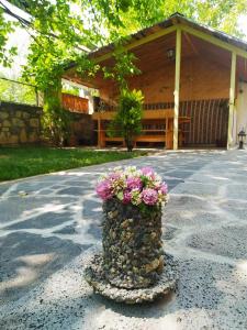 un vase rempli de fleurs assis au milieu d'une route dans l'établissement Guest house Nataly, à Yeghegnadzor