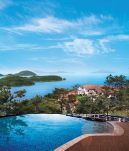 a swimming pool with a view of a body of water at Club ES Tongyeong Resort in Tongyeong