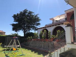 Aci CatenaにあるTerra Maison de Charme Siciliaの庭の塀と木のある家