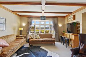 a living room with a couch and a table at Lake Brunner Eco Lodge in Moana