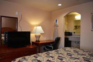 Pokój hotelowy z łóżkiem i biurkiem z telewizorem w obiekcie El Camino Motel w mieście Beeville