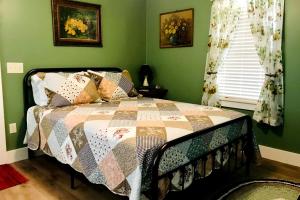 a bedroom with a bed with a quilt on it at Rockwood Motor Court in Springfield