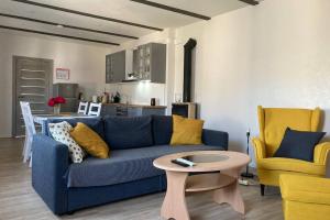 a living room with a blue couch and a table at Cozy family house in Ventspils