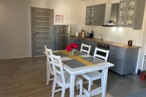 uma cozinha com uma mesa branca com cadeiras e um balcão em Cozy family house em Ventspils