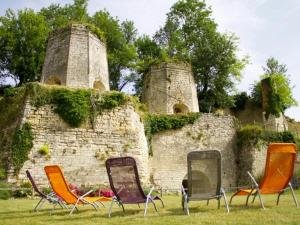 Gîte Foussais-Payré, 5 pièces, 8 personnes - FR-1-426-170 في Payré-sur-Vendée: ثلاثة كراسي جالسين في العشب أمام جدار حجري