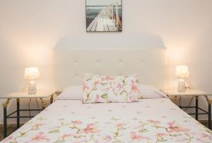 1 dormitorio con 1 cama con 2 mesas y 2 lámparas en Casa Eli, en Sardina