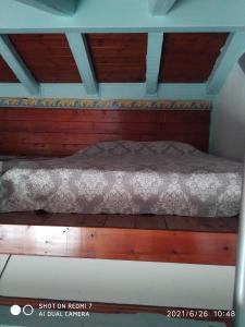 a bed with a wooden frame in a room at Country Art Studio Alkyoni in Kokkino Nero