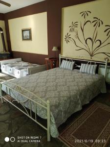a bedroom with two beds and a painting on the wall at Country Art Studio Alkyoni in Kokkino Nero