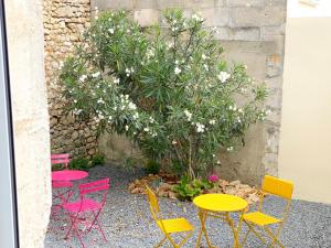 a group of colorful tables and chairs in a garden at Bleu Soleil Rochefort 3 étoiles in Rochefort