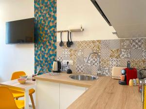 a kitchen with a sink and a table with chairs at Bleu Soleil Rochefort 3 étoiles in Rochefort