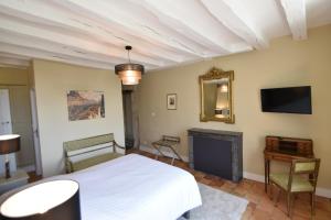ein Schlafzimmer mit einem weißen Bett und einem Kamin in der Unterkunft Les Destinées in Chinon