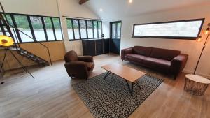 uma sala de estar com um sofá, cadeiras e uma mesa em FACTORY em Nogent-sur-Seine
