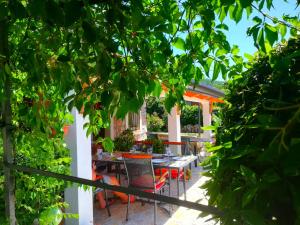 a patio with a table and chairs and trees at House Pelcic Kostrena in Kostrena
