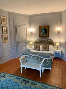 a bedroom with a bed and a chair in it at Château Ratou in Saint-Lys