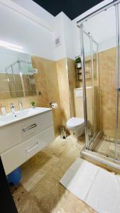 uma casa de banho com um chuveiro, um lavatório e um WC. em Maze Apartment em Mamaia Nord – Năvodari