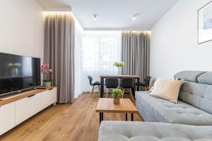 a living room with a couch and a table at WrocApartments StarCenter - Parking Free in Wrocław