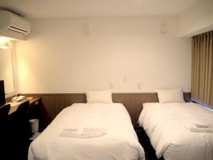 A bed or beds in a room at Hotel Excellence Enmachi Ekimae