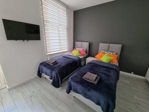 two beds in a room with two windows at Apartamenty Katowice Stawowa 5 in Katowice