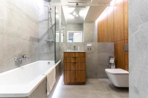 a bathroom with a tub and a sink and a toilet at WrocApartments StarCenter - Parking Free in Wrocław