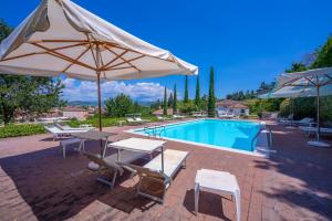 een zwembad met twee tafels en twee parasols ernaast bij Villa Faccioli Limone With Shared Pool in Colognola ai Colli