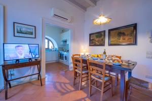 una sala da pranzo con tavolo e TV di Villa Faccioli Limone With Shared Pool a Colognola ai Colli